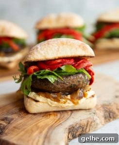 one portobello mushroom sandwich on wooden board with 3 more blurred in the background