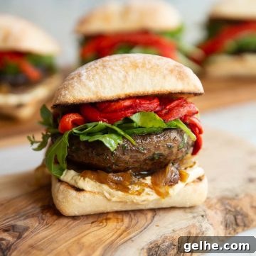 one portobello mushroom sandwich on wooden board with 3 more blurred in the background