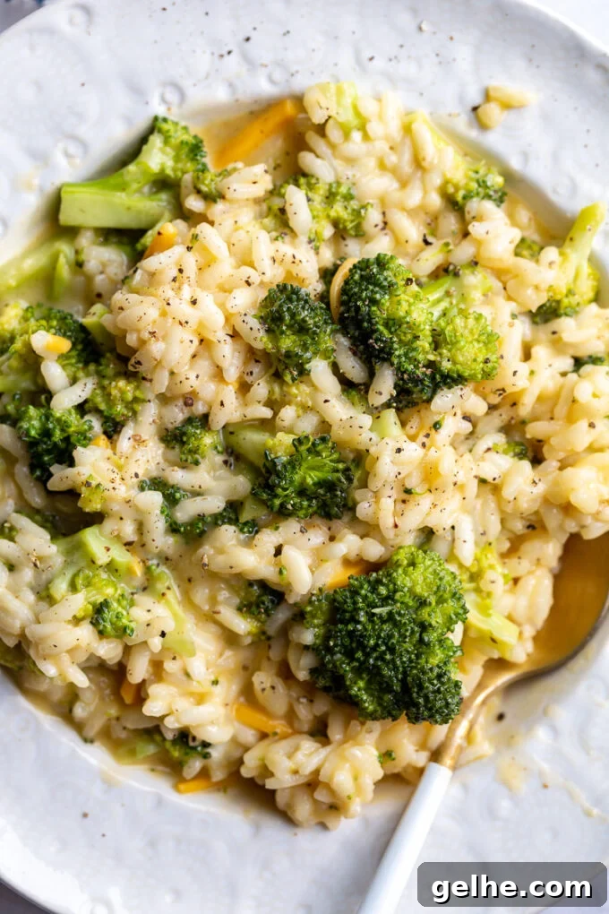 Broccoli Cheese Risotto served in a white bowl with a spoon.