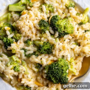 Broccoli Cheese Risotto served in a white bowl with a spoon.