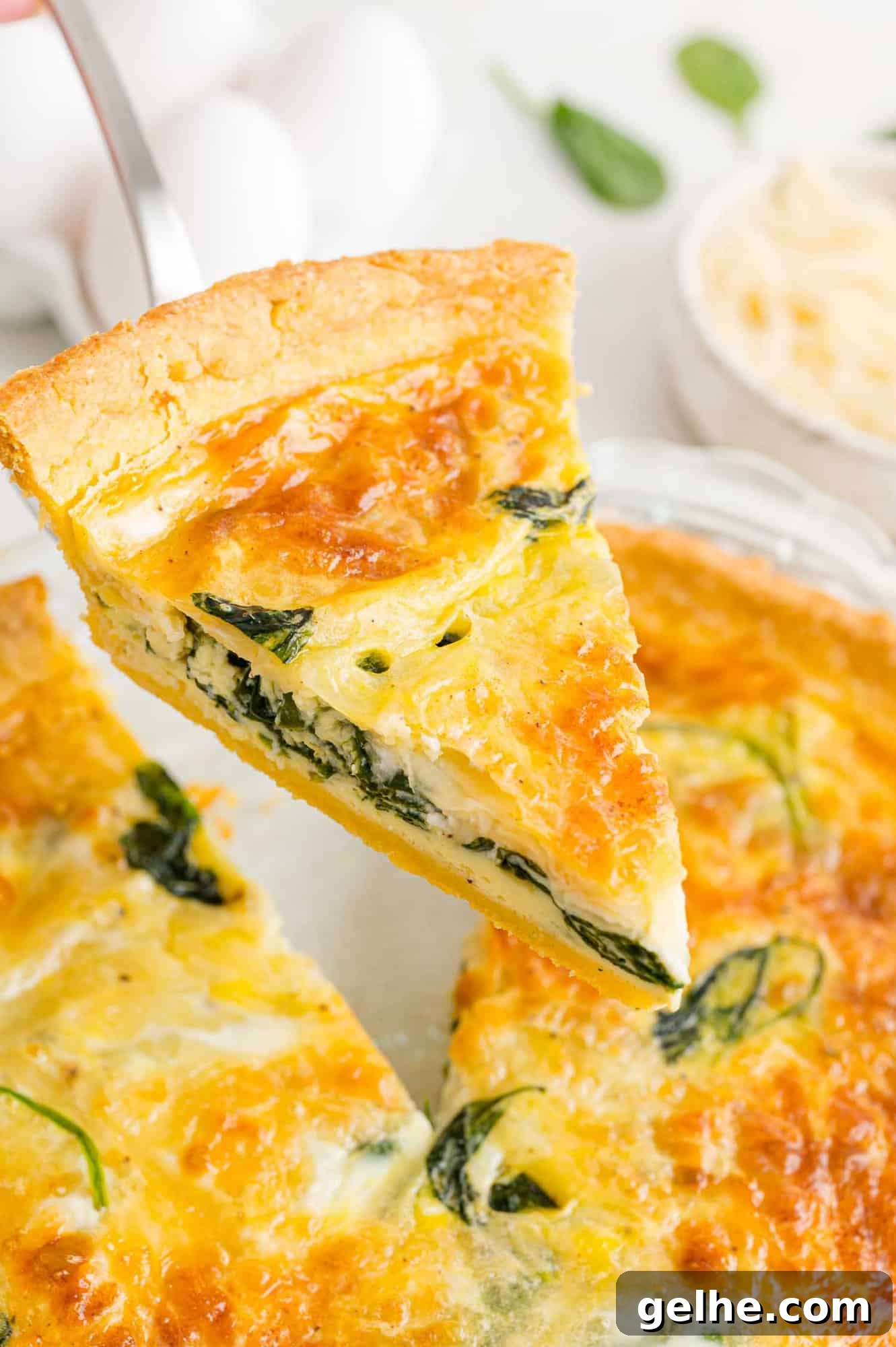 Slice of spinach quiche being served.