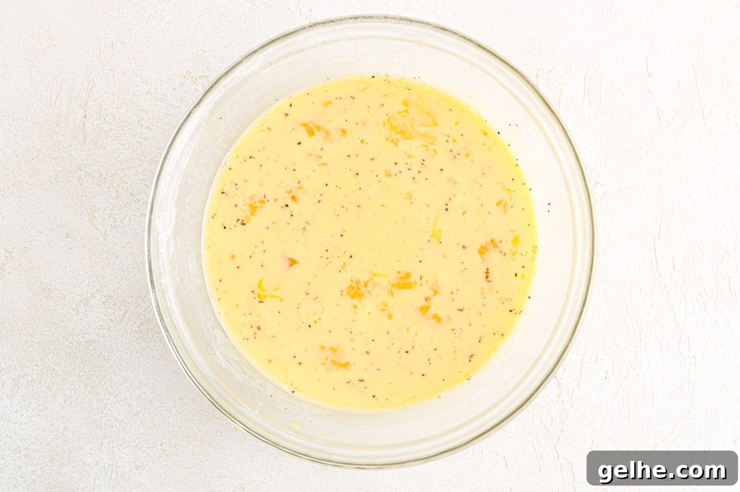 Egg mixture in a glass mixing bowl.