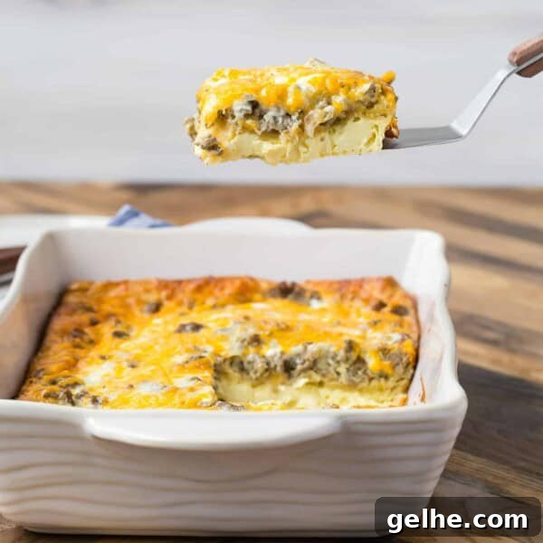 9x13 pan of breakfast casserole made with crescent rolls, one slice being lifted from the pan on a spatula.