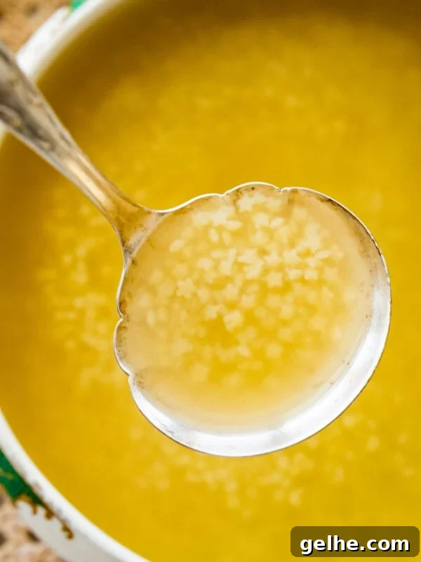 A pot of Italian penicillin soup with a ladle lifting up a bit.