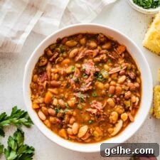 White bowl of 15 bean soup with ham.