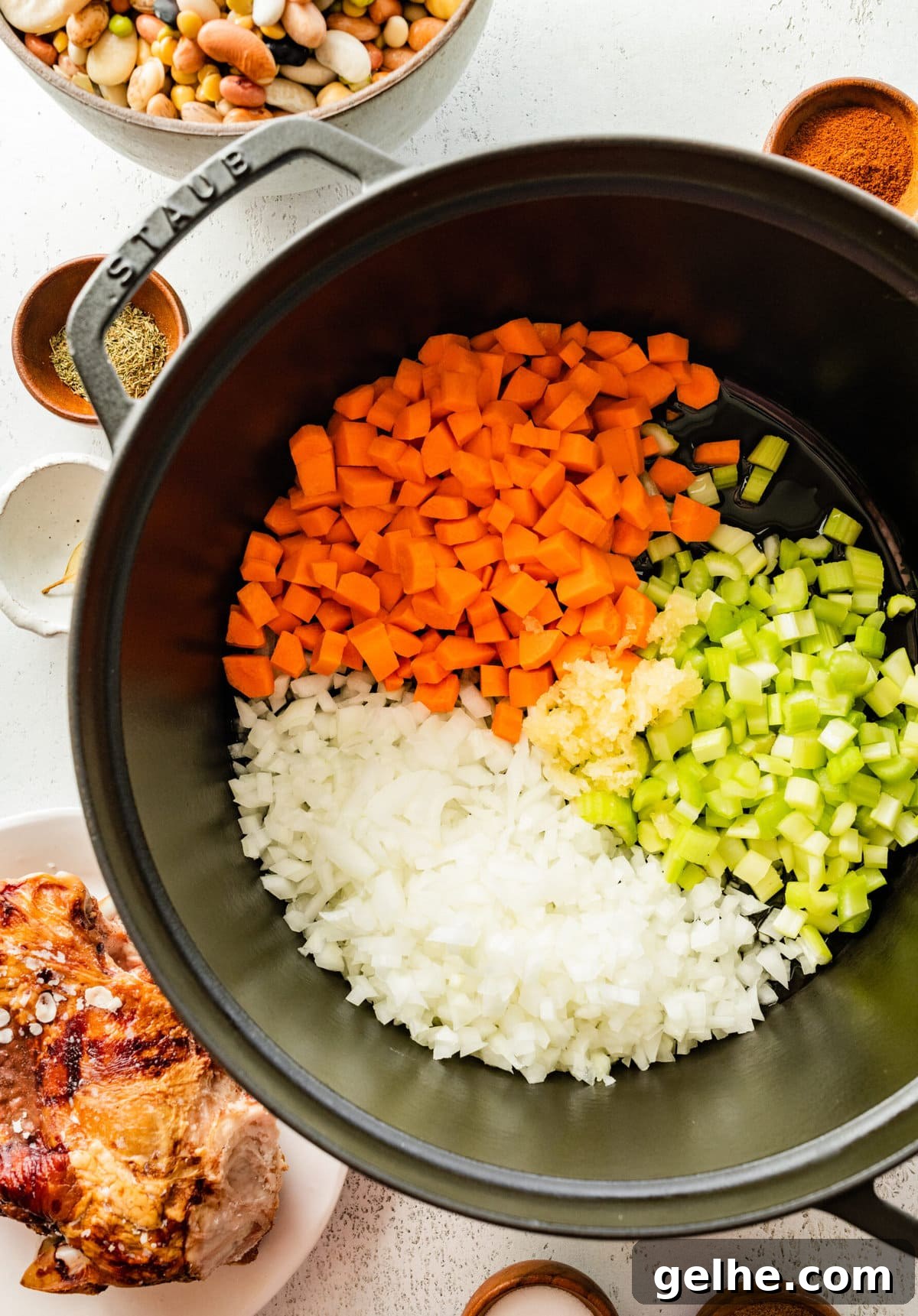 how to make 15 bean soup mix recipe with ham Step by Step: cooking onion, carrots, and celery in a cast iron pot.