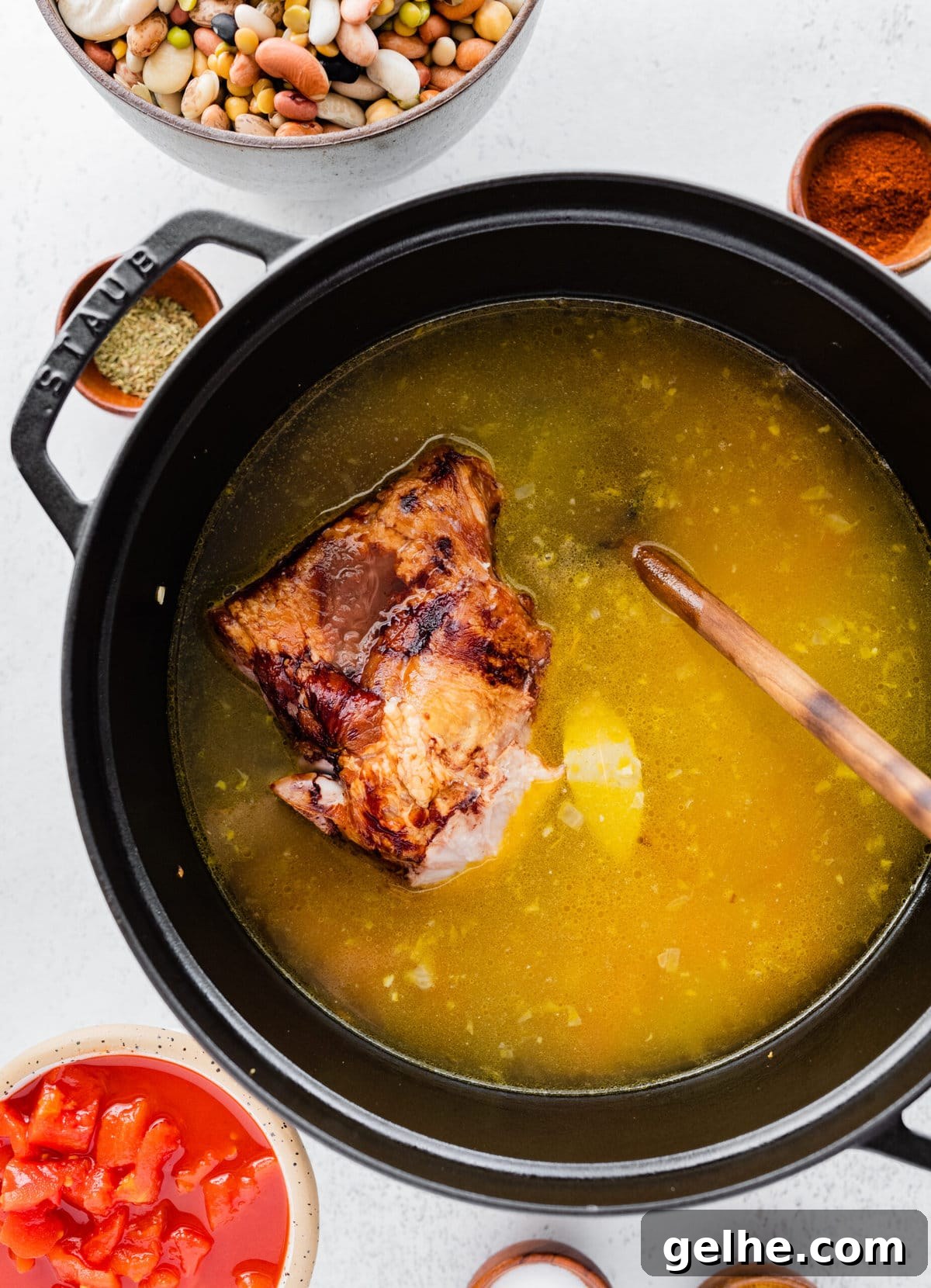 how to make 15 bean soup mix recipe with ham Step by Step: adding broth and bay leaf to the pot with ham hock and veggies.