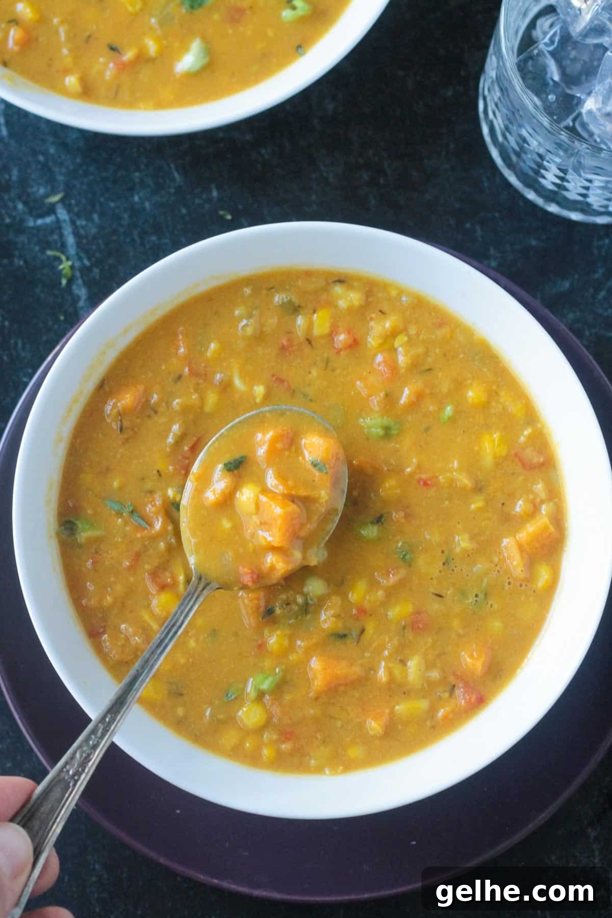 Spoonful of soup being lifted from a bowl.