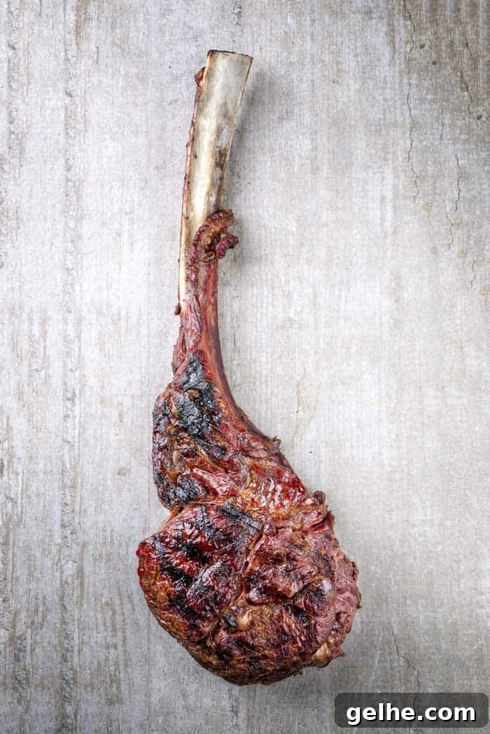 reverse seared tomahawk on white wood board background
