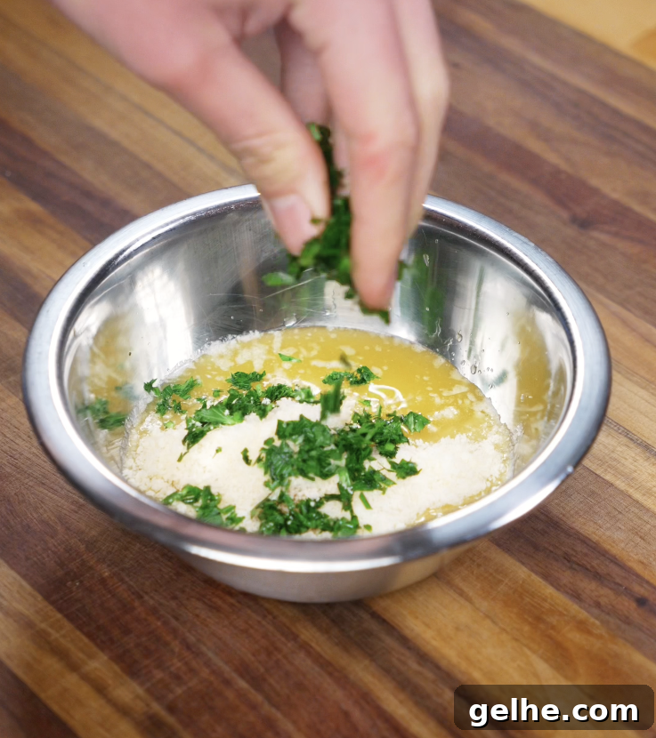 Korean Garlic Cheese Bread Recipe — Crispy, Cheesy Garlic Pull-Apart 5 Chopped parsley is sprinkled into a bowl of melted butter and parmesan to create the garlic butter glaze.