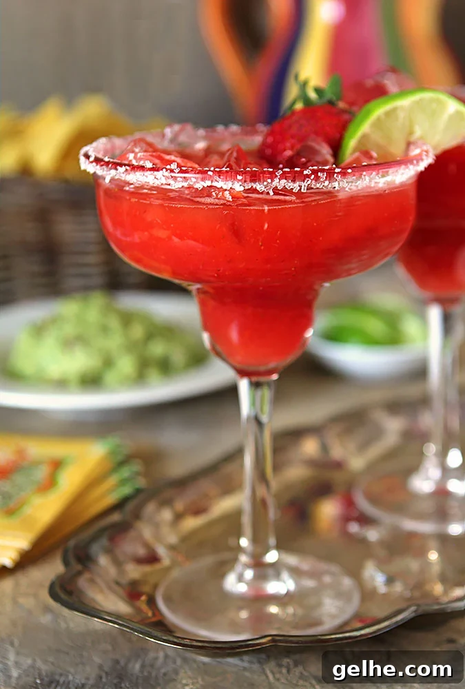 Fresh Strawberry Margarita Cocktail served in a margarita glass and garnished with a strawberry and lime wedge.