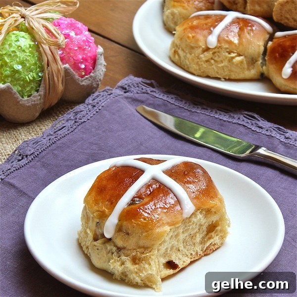 17 Delicious Vegetarian Easter Dinner Ideas for a Memorable Feast 6 A Hot Cross Bun on a plate, topped with a white cross, with more buns in the background.