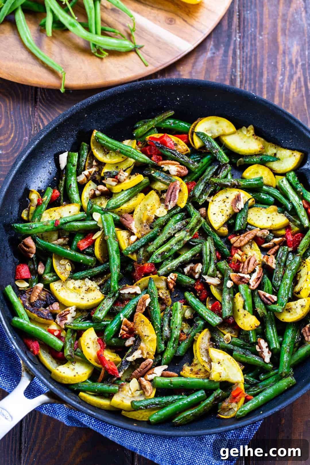 Green beanns and squash in skillet with pecans.