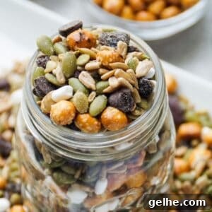 Up close image of nut free trail mix in a glass mason jar (top view). Trail mix also around the base of the glass jar.