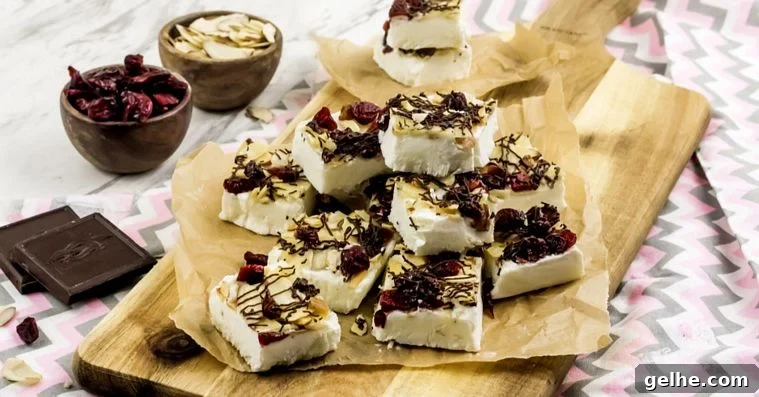Toasted Almond Cranberry Bark Recipe with Step-by-Step Photos 6 WW Yogurt Bark finished and stacked on a sheet of parchment paper on top of a wooden cutting board.