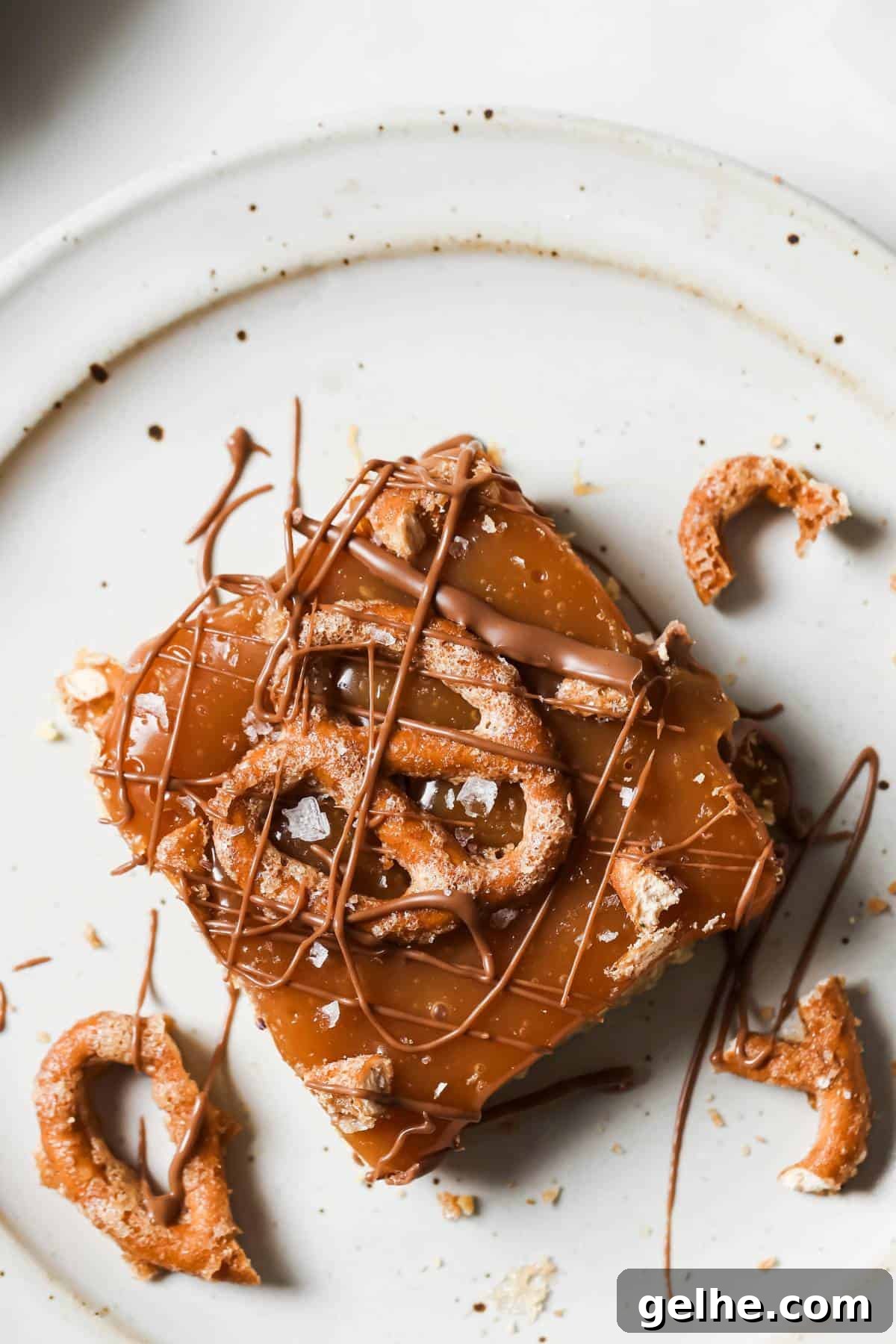 Caramel Cookie Bars on a white ceramic plate with a drizzle of chocolate.
