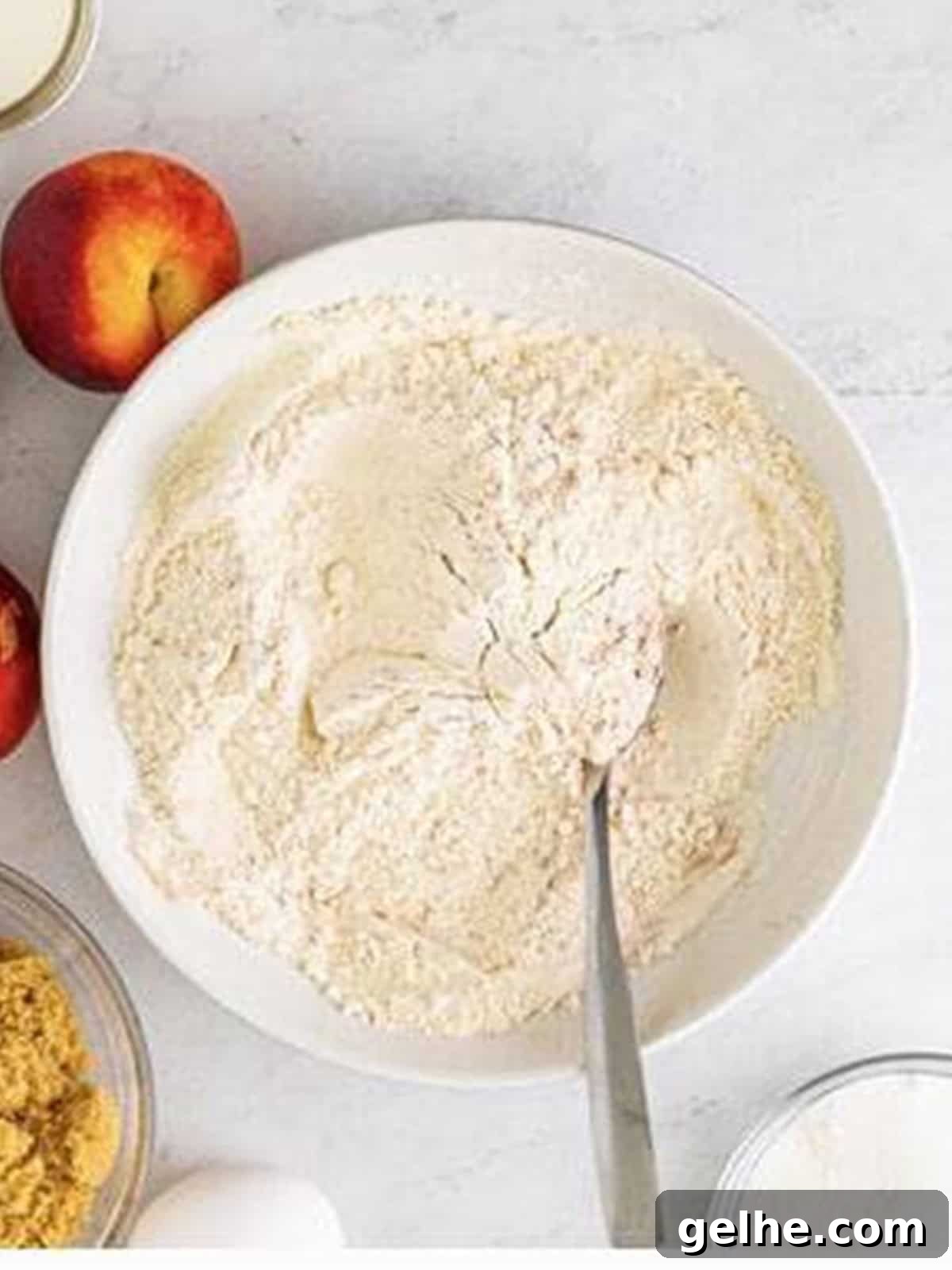Flour, baking powder, salt, and cinnamon stirred together in a bowl.