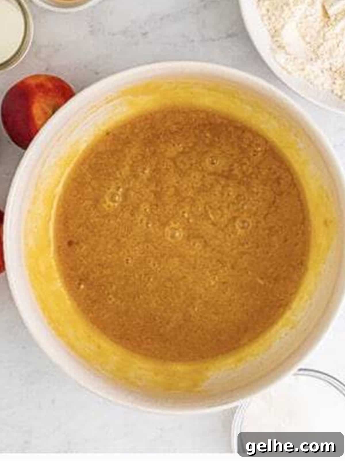 Oil, brown sugar, eggs, sour cream, and vanilla whisked smooth in a bowl.