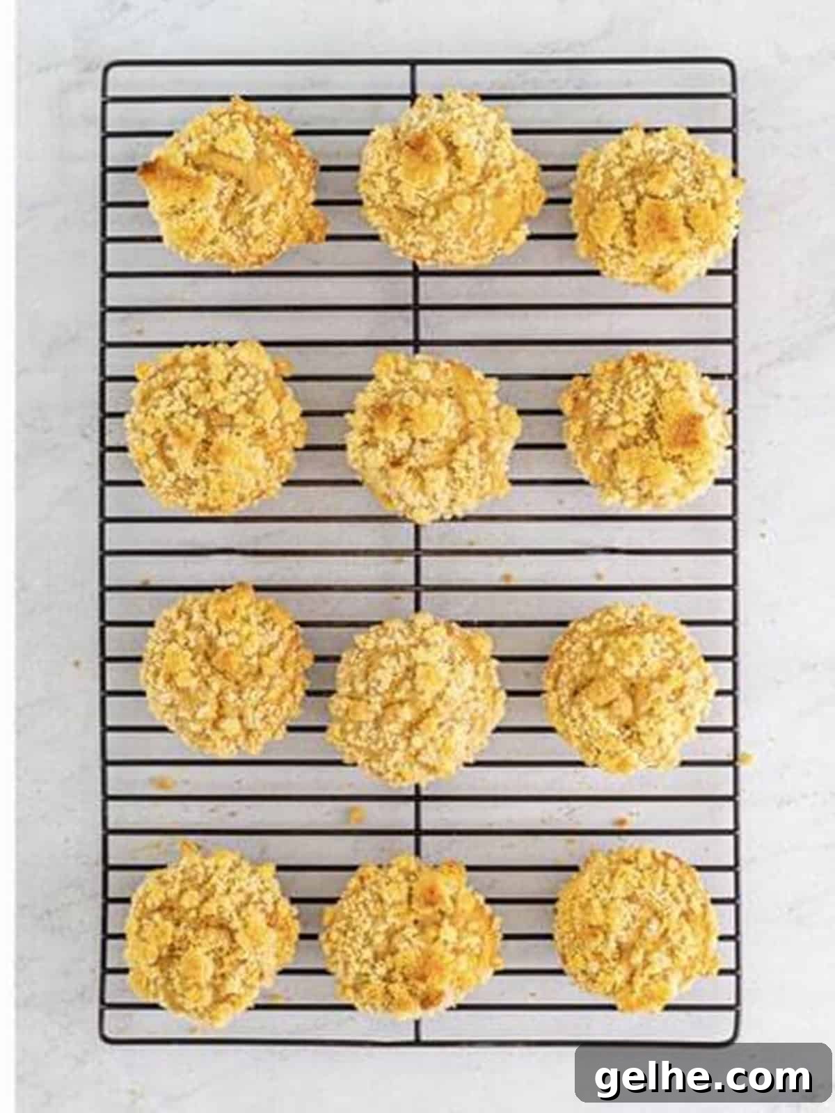 Golden baked peach muffins cooling on a wire rack.