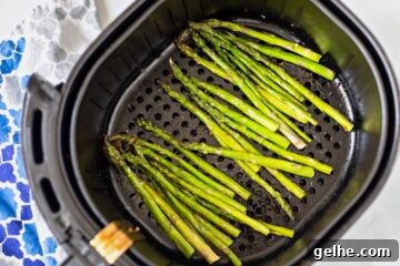 Asparagus in air fryer basket before cooking.