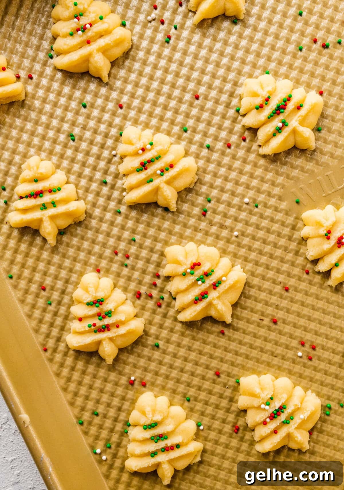 How to make Spritz cookies step-by-step: baked cookies on a baking sheet. Christmas trees with sprinkles.