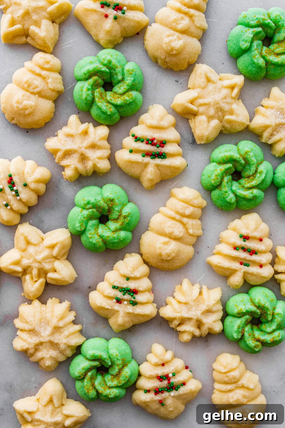 All the decorated spritz cookies on a marble countertop.