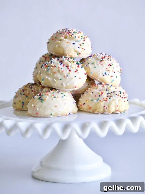 Pile of Anginetti cookies with sprinkles on a raised platter.