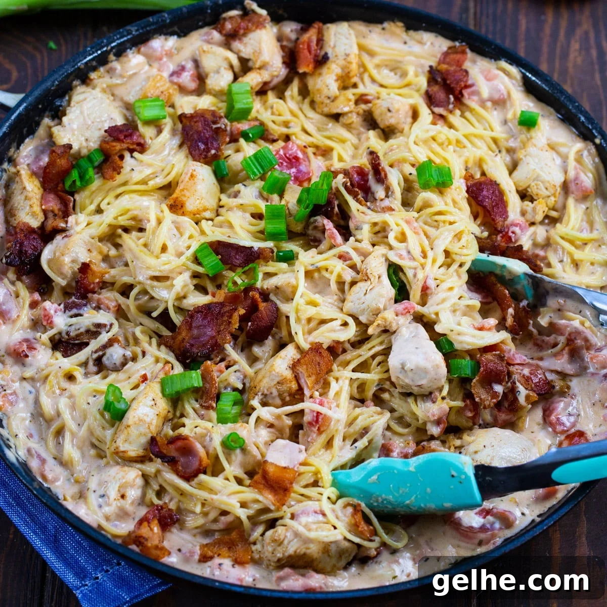 Creamy Angel Hair Pasta with Bacon and Chicken in a skillet.