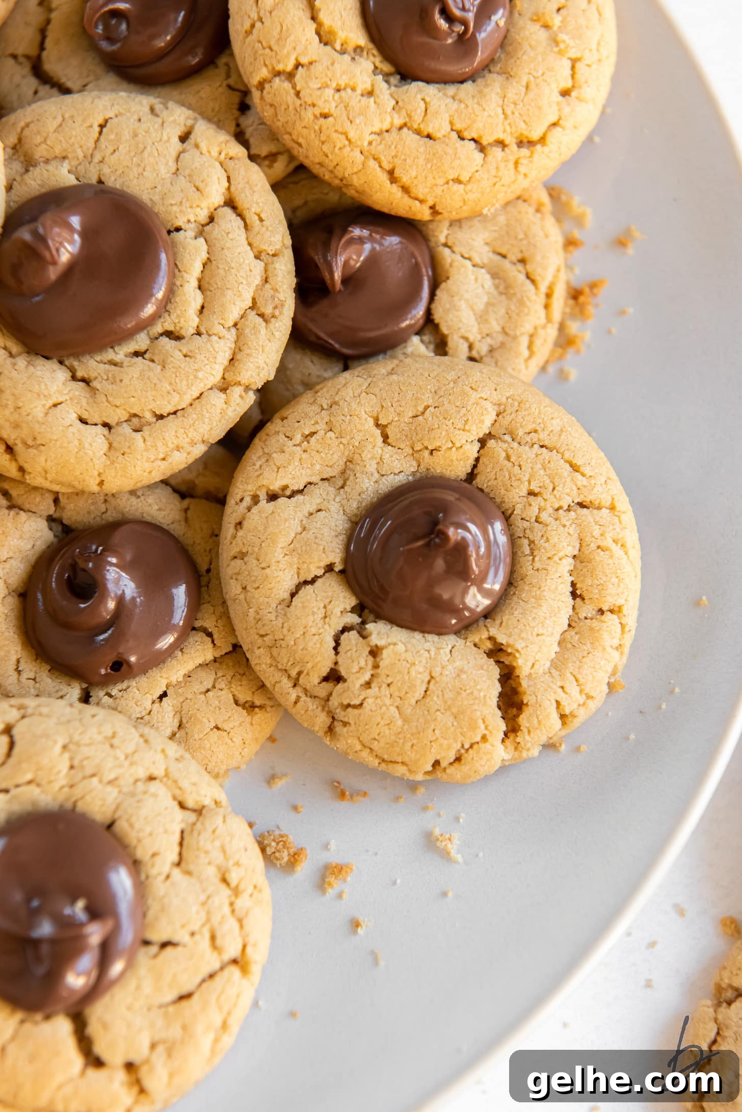 plate of peanut butter nutella cookies with nutella in thumbprint center.