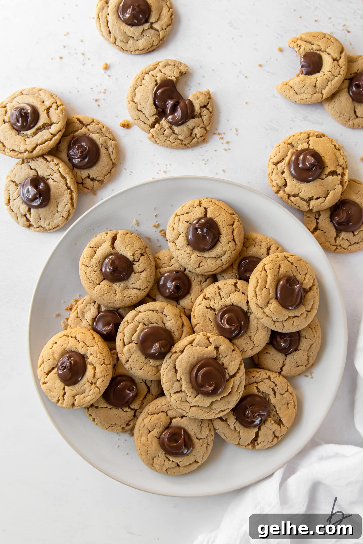 peanut butter nutella cookies on plate next to a few more cookies with nutella centers.