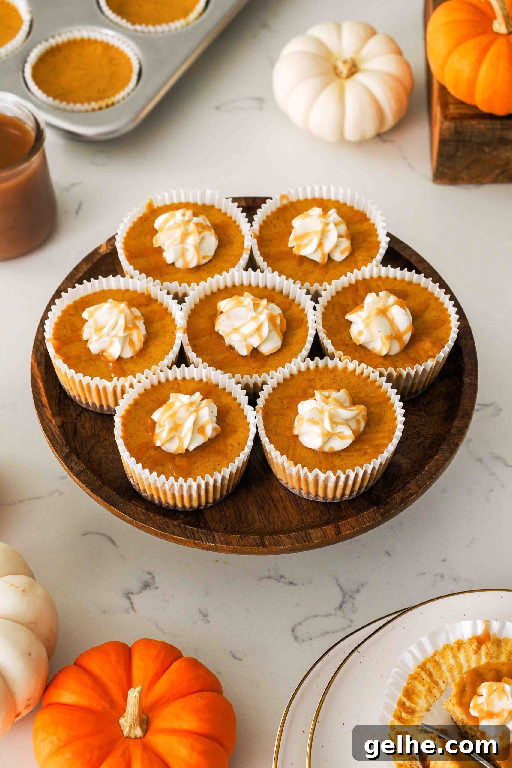 Mini Pumpkin Cheesecake Bites: Creamy Fall Dessert Recipe 2 Mini pumpkin cheesecakes on a wooden cake stand.