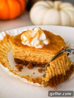 Mini Pumpkin Cheesecake Bites: Creamy Fall Dessert Recipe 17 A fork removes a piece of a mini pumpkin cheesecake on a plate.