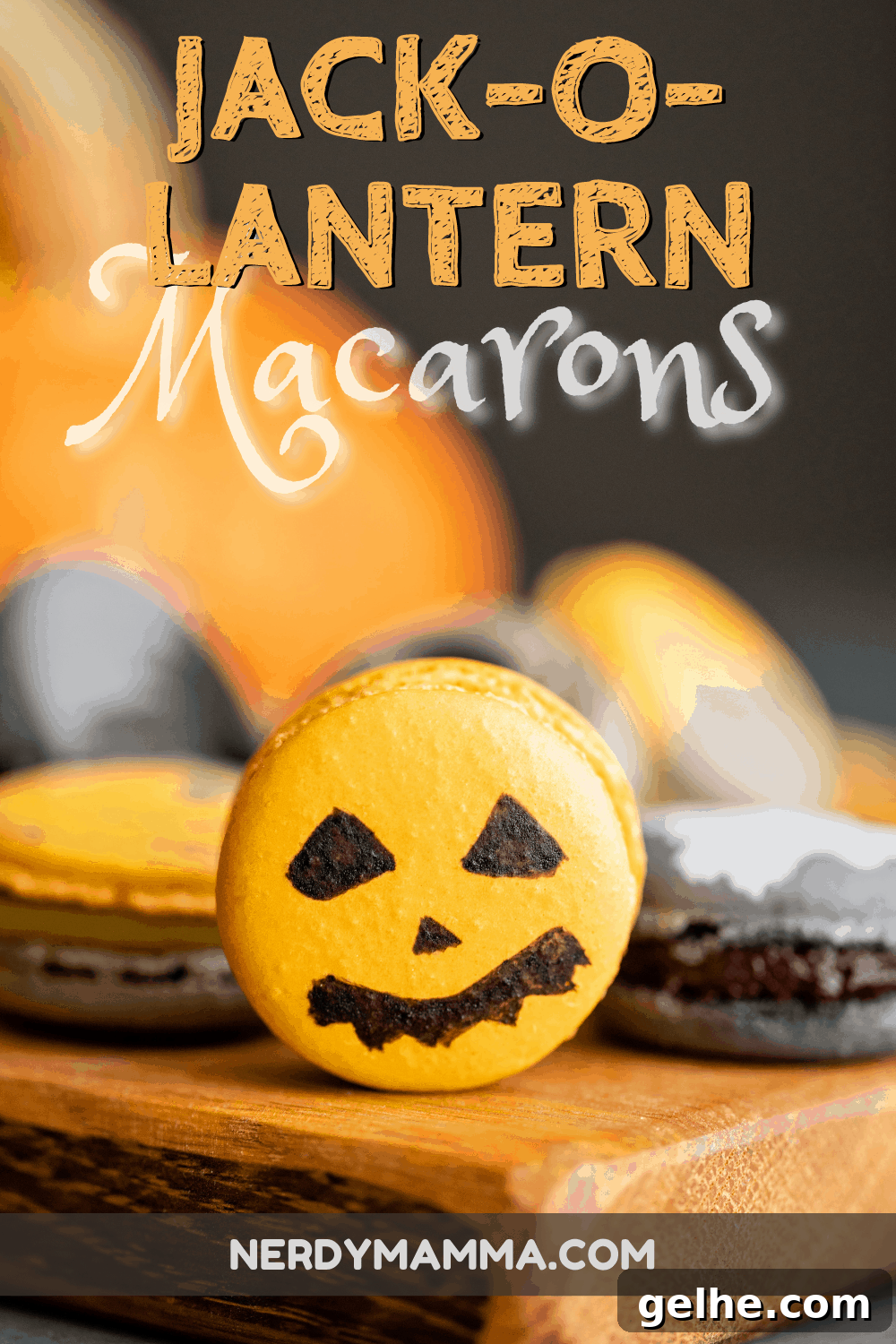 A close-up of a bright orange Jack-O-Lantern Macaron with a spooky face, displayed on a wooden board with other Halloween-themed macarons in the background.