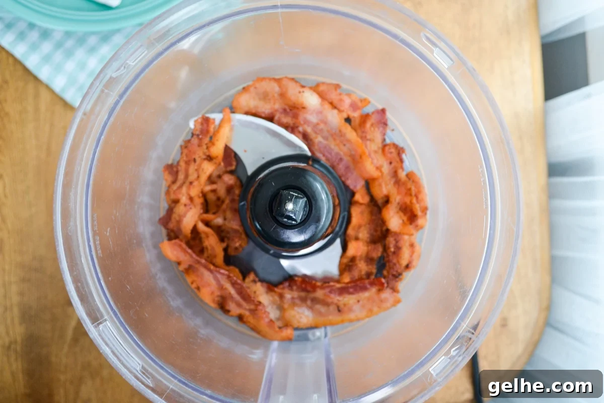 Bacon being added to the food processor.