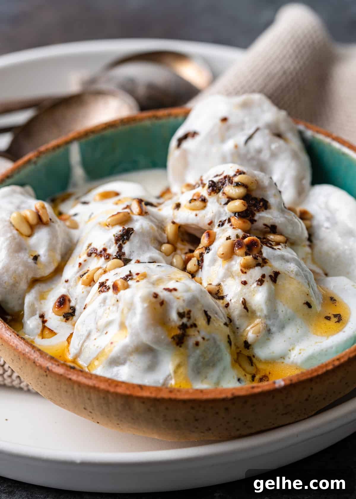 closeup: bowl with lebanese meat dumpling covered in yogurt sauce