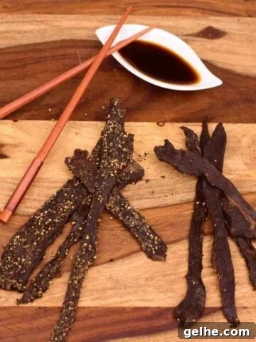 Deer jerky on cutting board with marinade in white dish