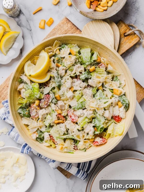 Chicken caesar pasta salad tossed in a large bamboo mixing bowl.