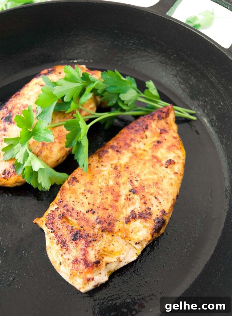 Perfectly Pan-Seared Chicken Breasts: Juicy, Crispy Results Every Time 7 Two chicken breasts in a cast iron skillet with fresh parsley