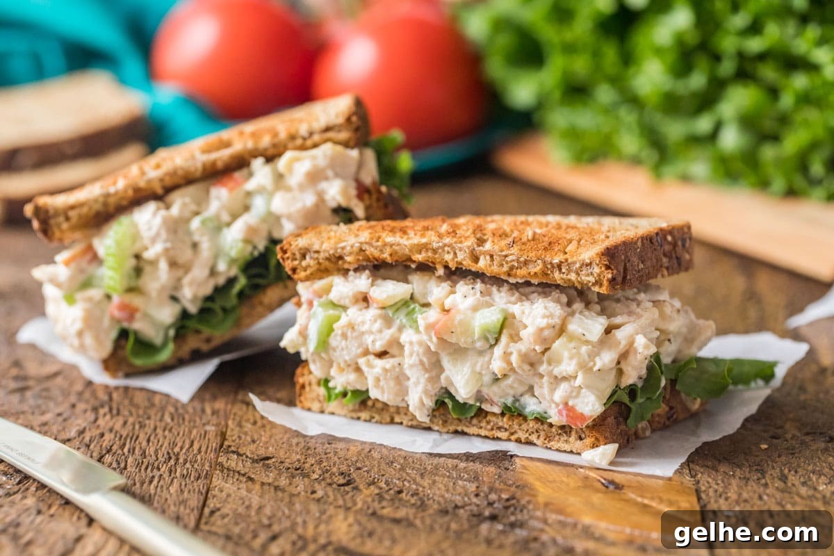 Halves of a sandwich made with diced chicken, mayo, apples, and more.