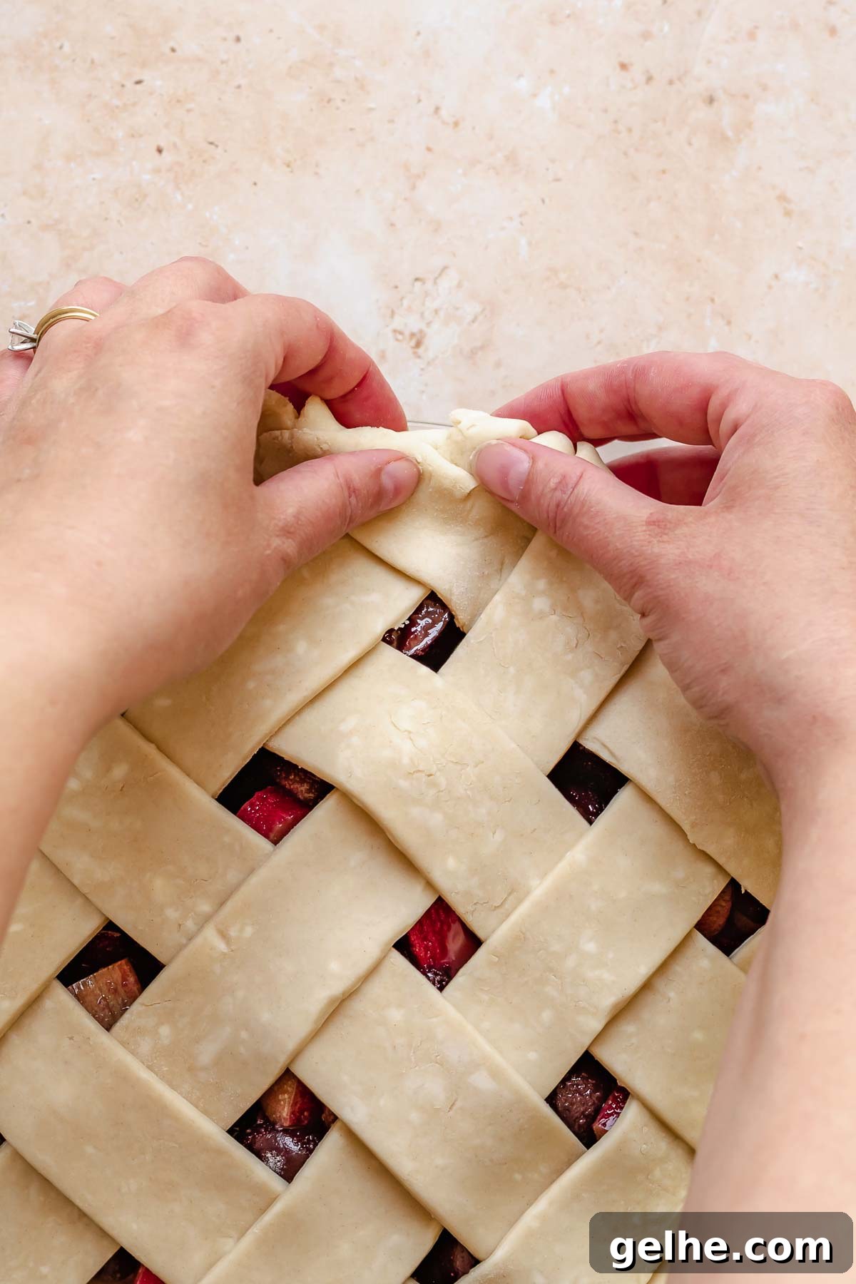 Cherry Rhubarb Pie Recipe: Sweet-Tart Homemade Dessert 13 Hands fold excess pie dough under itself.