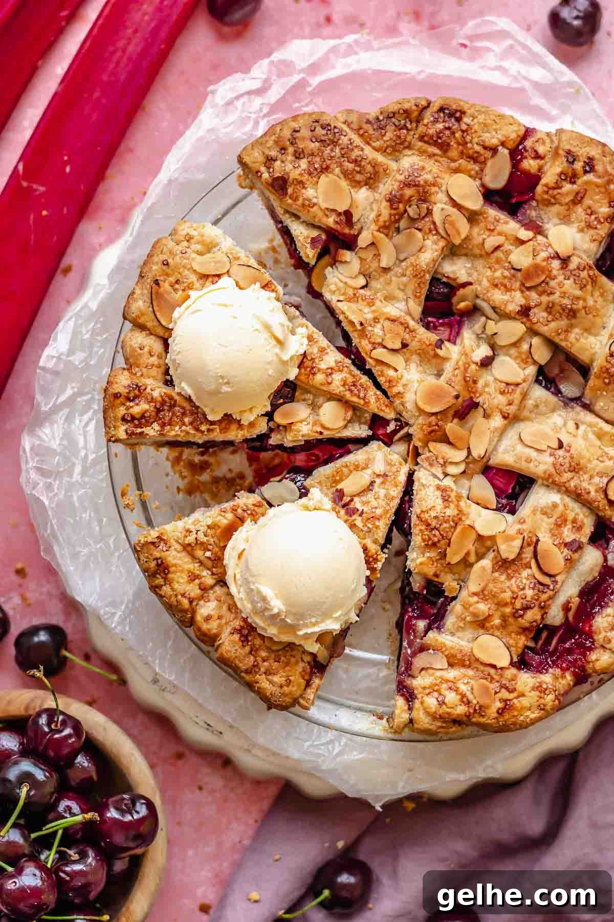 Cherry Rhubarb Pie Recipe: Sweet-Tart Homemade Dessert 16 Sliced fruit pie with ice cream scoops on two of the pieces.