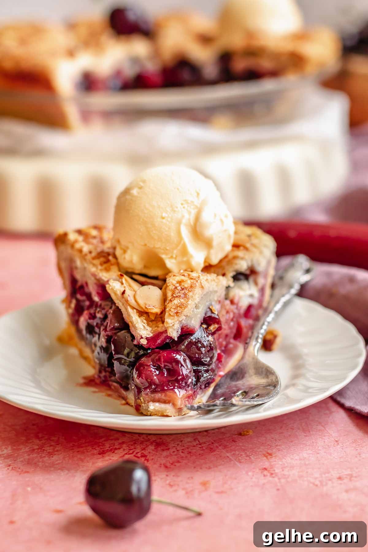 Cherry Rhubarb Pie Recipe: Sweet-Tart Homemade Dessert 17 A slice of cherry rhubarb pie on a plate with a scoop of ice cream on top.