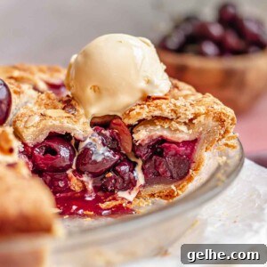 Cherry Rhubarb Pie Recipe: Sweet-Tart Homemade Dessert 18 Cherry rhubarb pie slice exposed in a pie pan with ice cream melting on top.