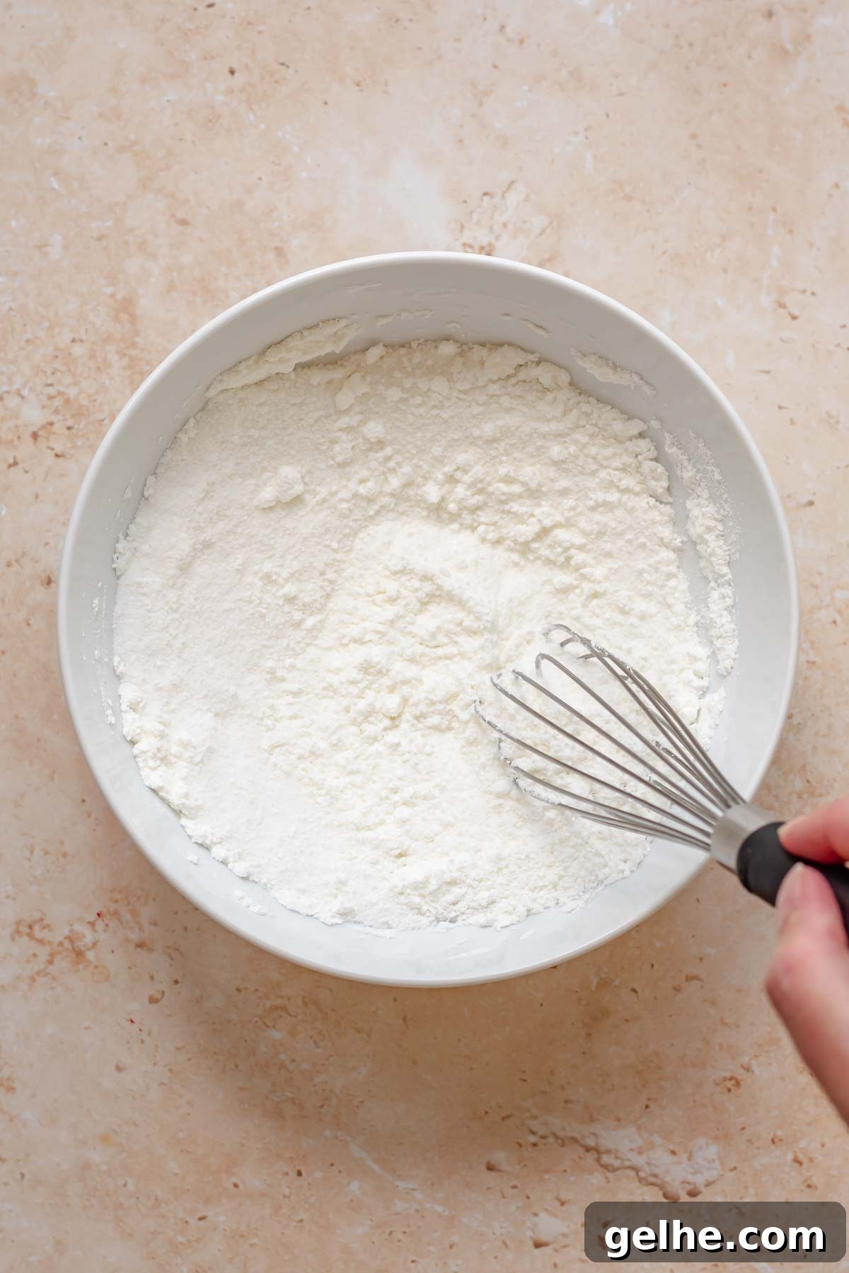 Cherry Rhubarb Pie Recipe: Sweet-Tart Homemade Dessert 5 A hand whisks together sugar and cornstarch in a bowl.