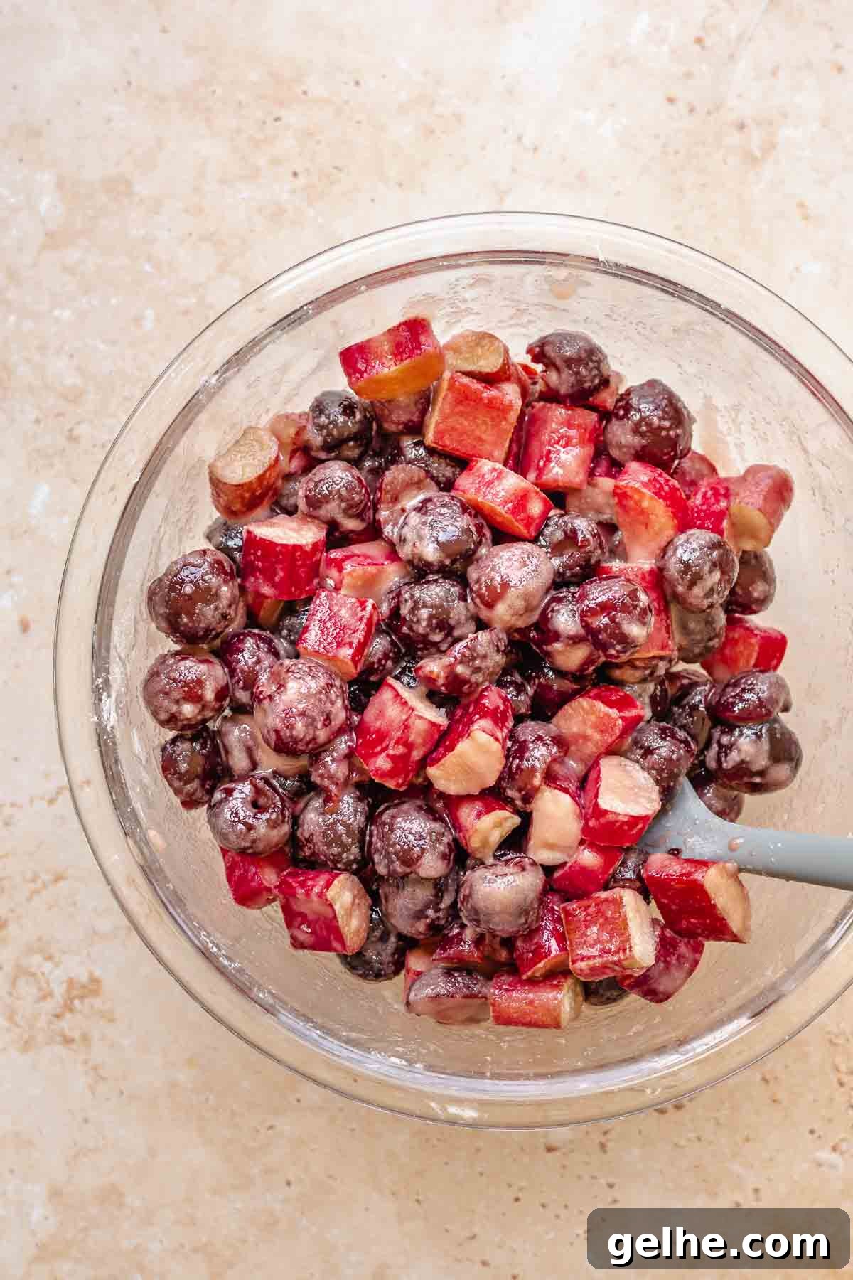 Cherry Rhubarb Pie Recipe: Sweet-Tart Homemade Dessert 6 A spatula folds together the fruit and sugar-cornstarch mixture in a bowl.