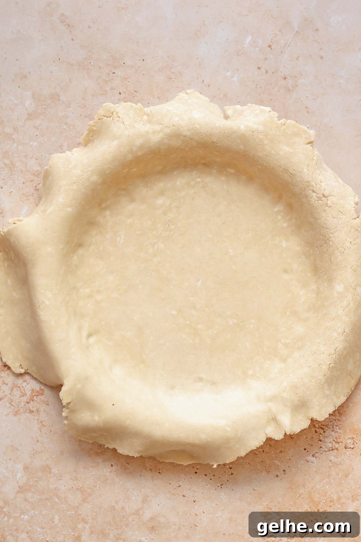 Cherry Rhubarb Pie Recipe: Sweet-Tart Homemade Dessert 8 Pie crust fitted into a pie dish with pastry hanging over the sides.