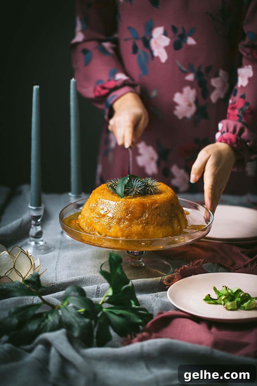 Traditional British Golden Syrup Steamed Sponge Pudding 2 woman's hands reach in to cut a perfect large steamed pudding, freshly cooked and oozing gorgeous golden syrup