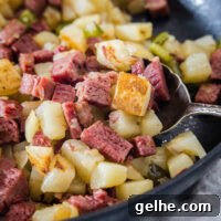 Classic Corned Beef Hash Recipe: Crispy Skillet Breakfast 2 Close up of corned beef hash in a skillet with a serving spoon.