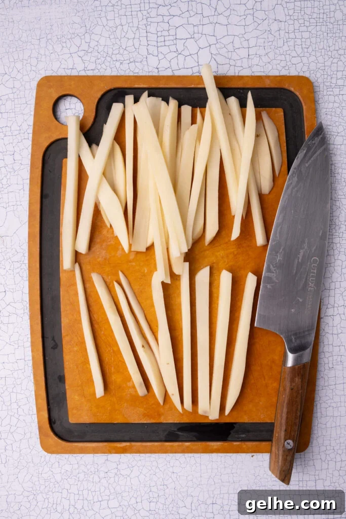 Crispy Cajun Fries: Oven or Air Fryer Recipe for Perfect Seasoning 5 Cutting potatoes slices into strips to make fries.