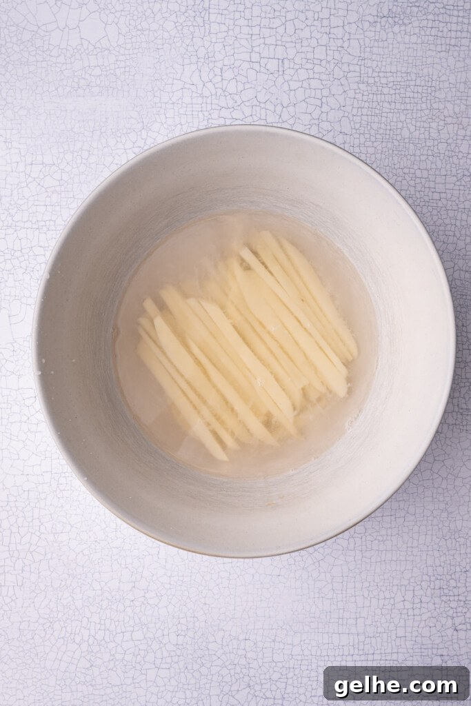 Crispy Cajun Fries: Oven or Air Fryer Recipe for Perfect Seasoning 6 Soaking hand-cut fries in water to remove excess starch.